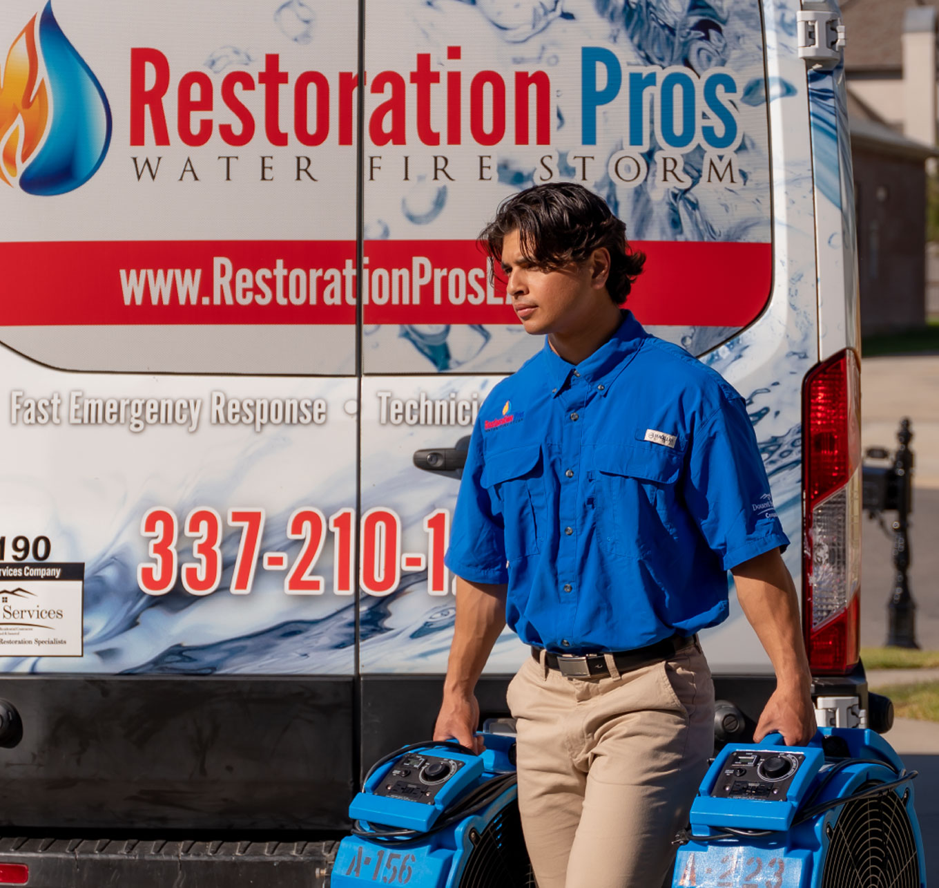 Restoration Pro technician carry water damage restoration fans